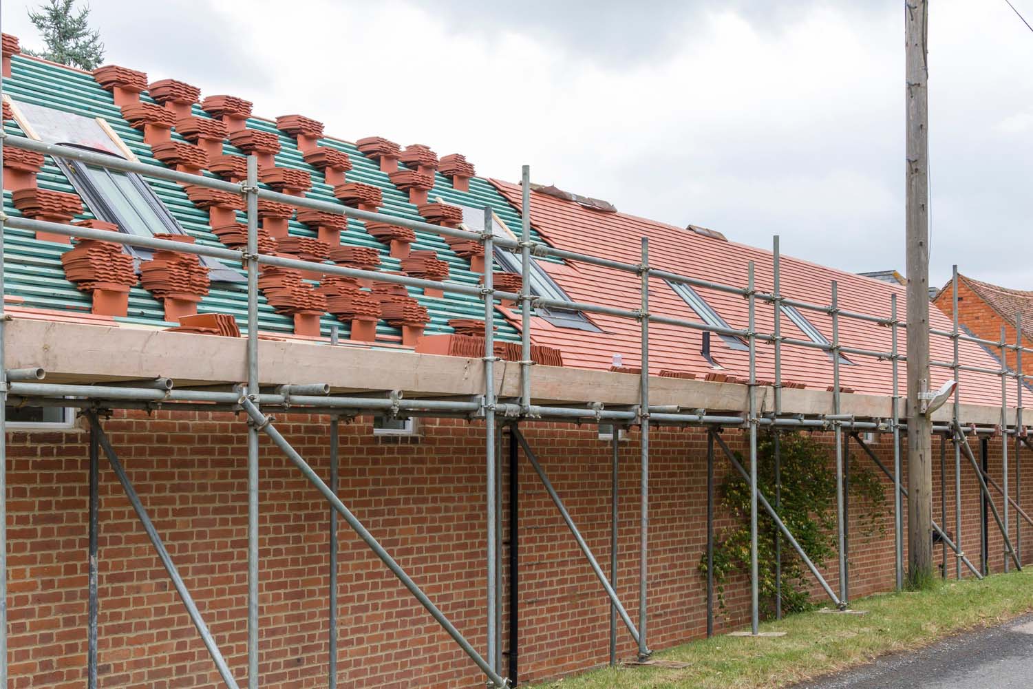 Scaffolding and roof repairs on a house in UK. Scaffolding and roof repairs, replacing roof tiles on a rural house in Buckinghamshire, UK